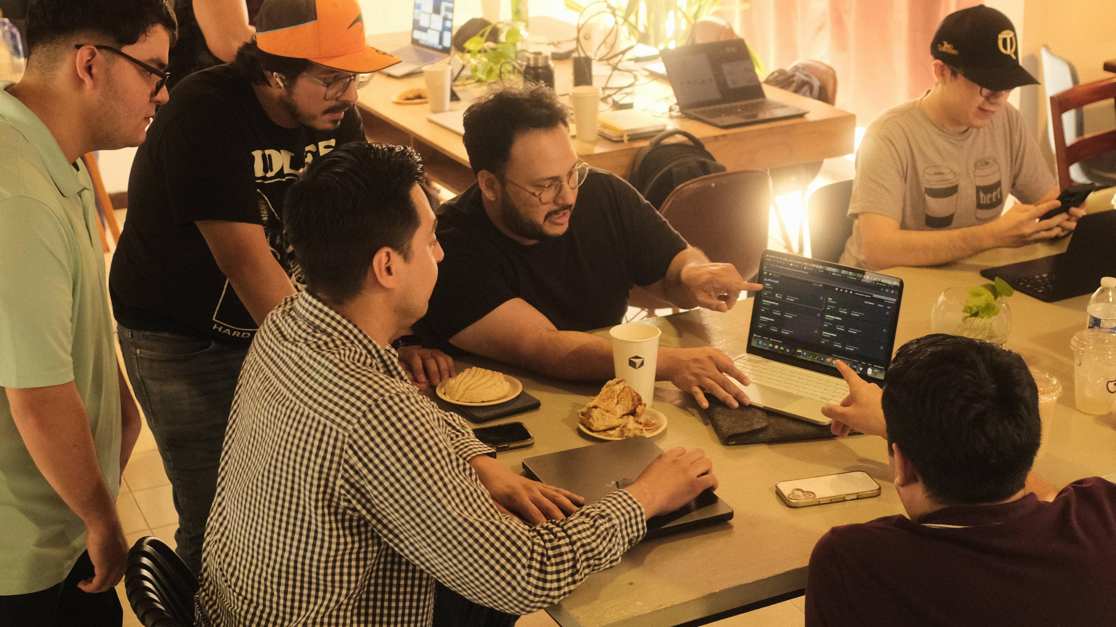 Group debugging together around a laptop in Culiacán