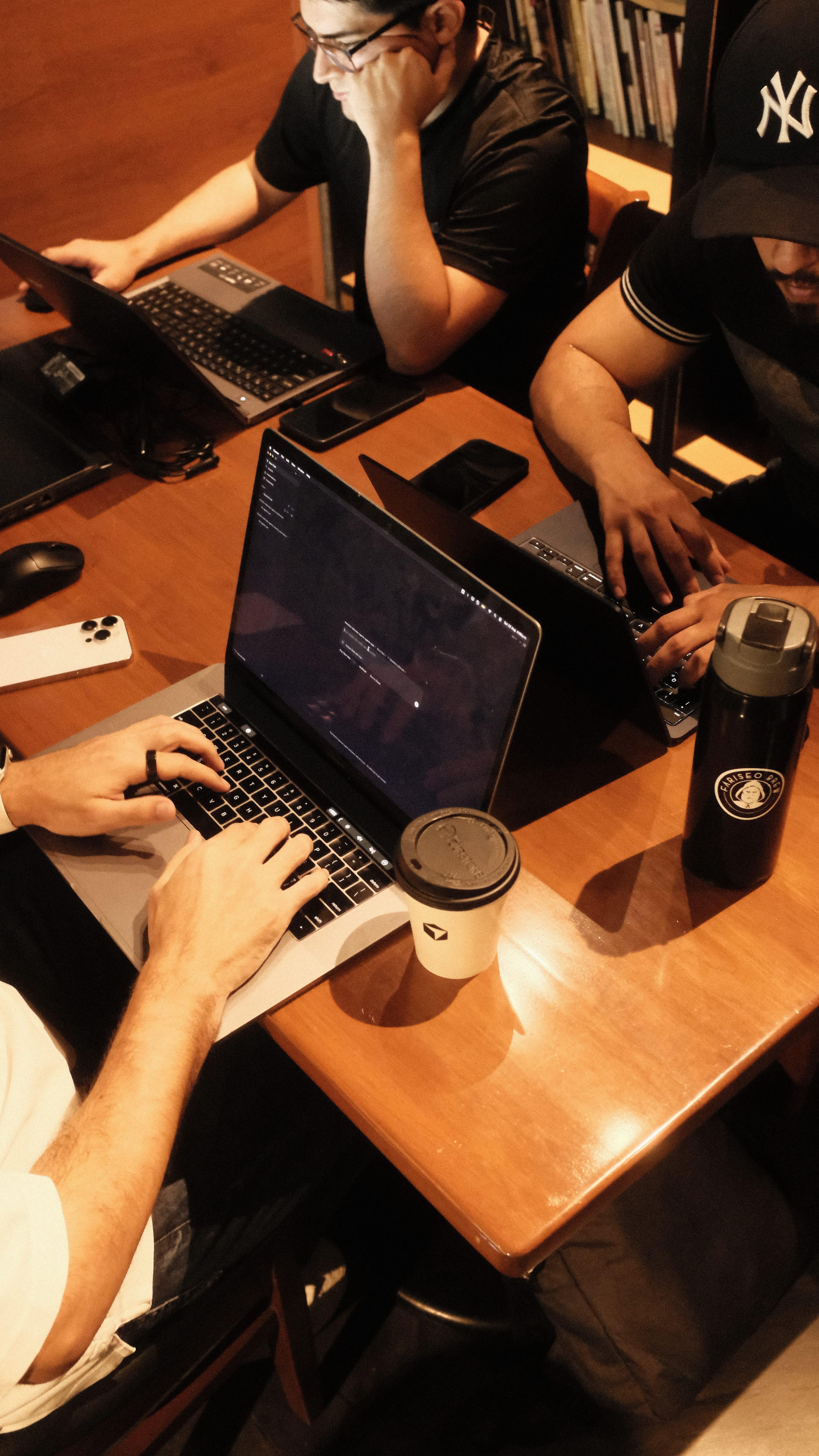 Builders coding together at a wooden table during Cafe Cursor Culiacán