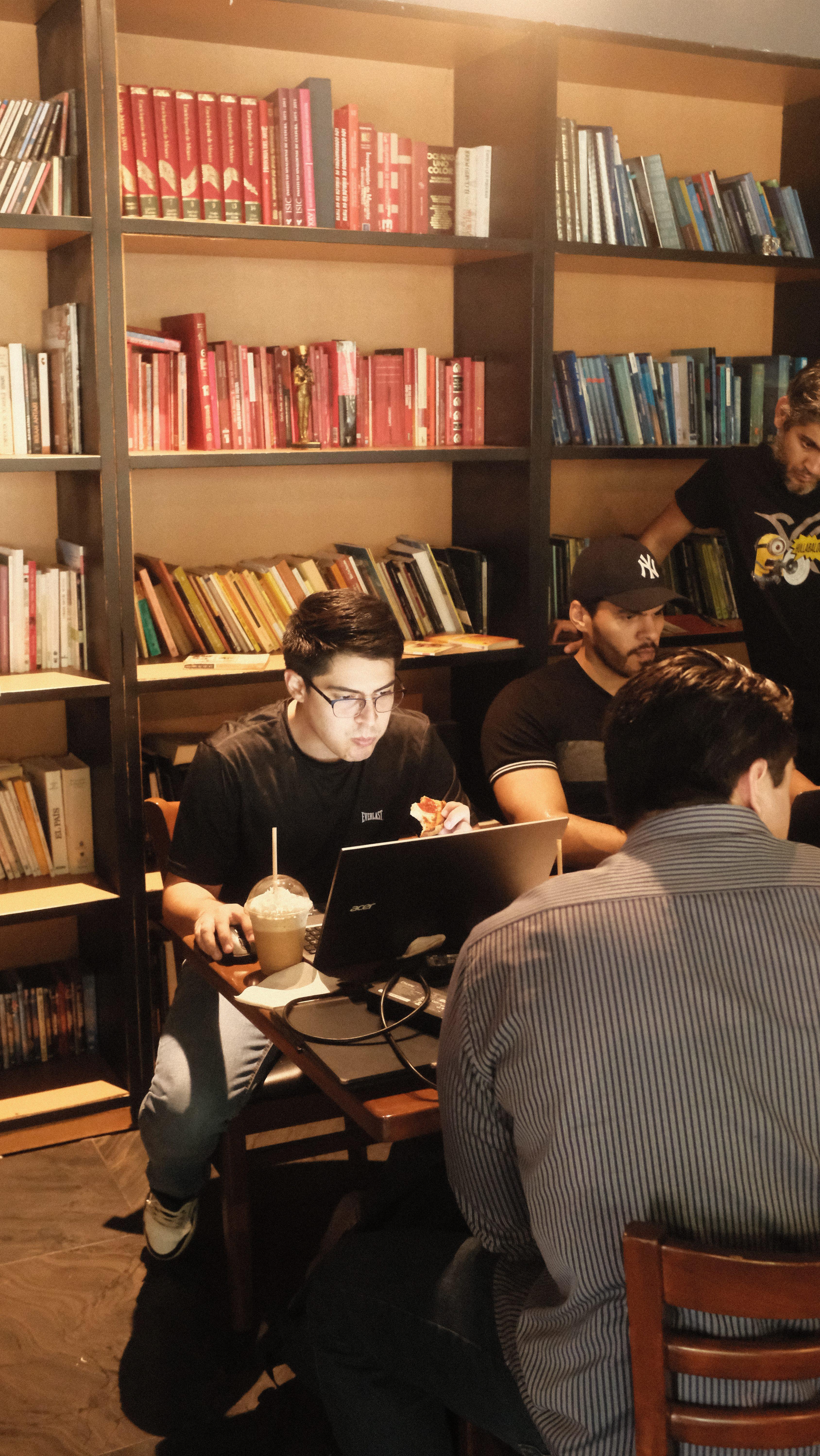 Builders sharing a laptop at a table during Cafe Cursor Culiacán