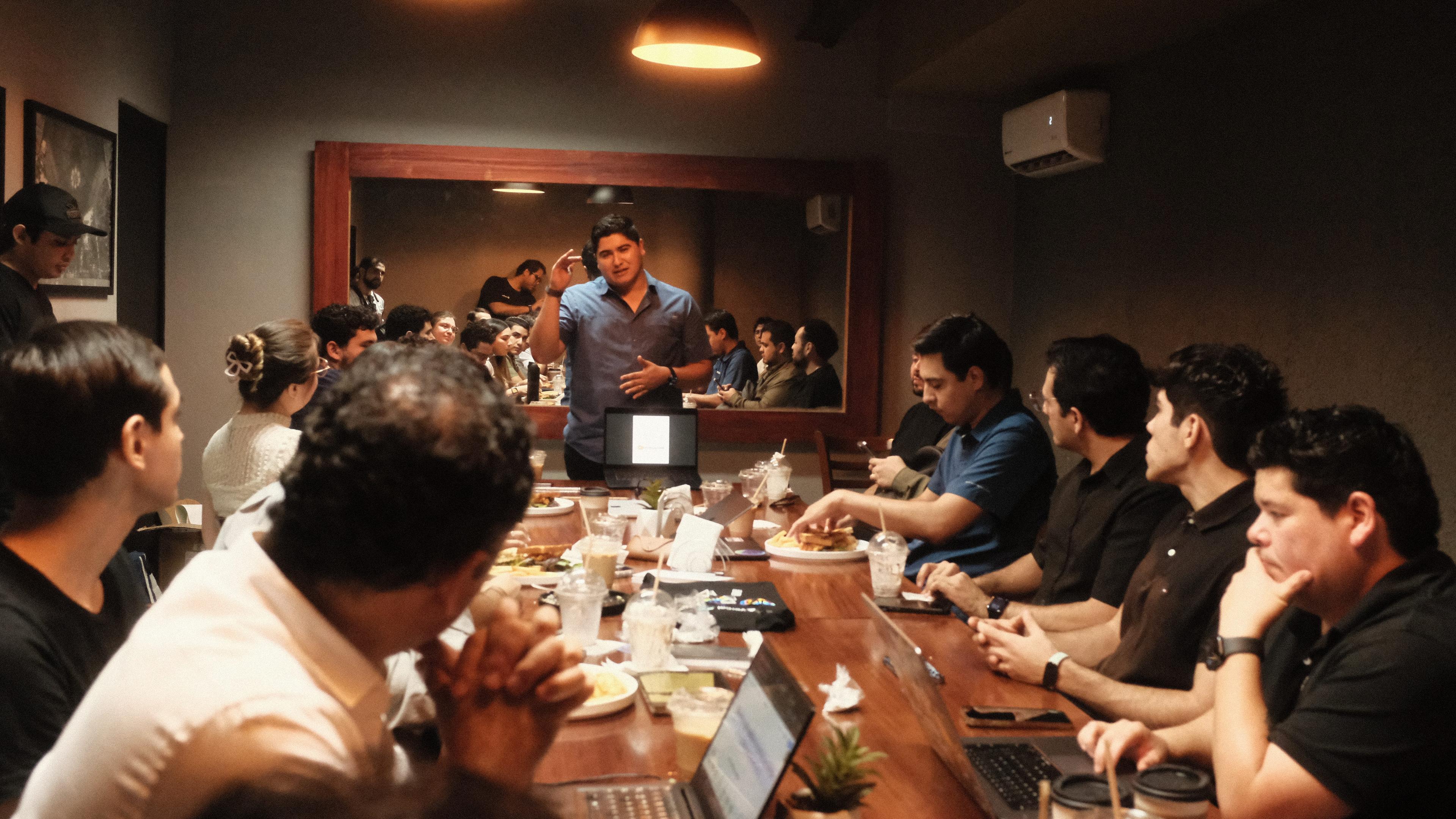 Speaker presenting to builders around a long table at Cafe Cursor Culiacán