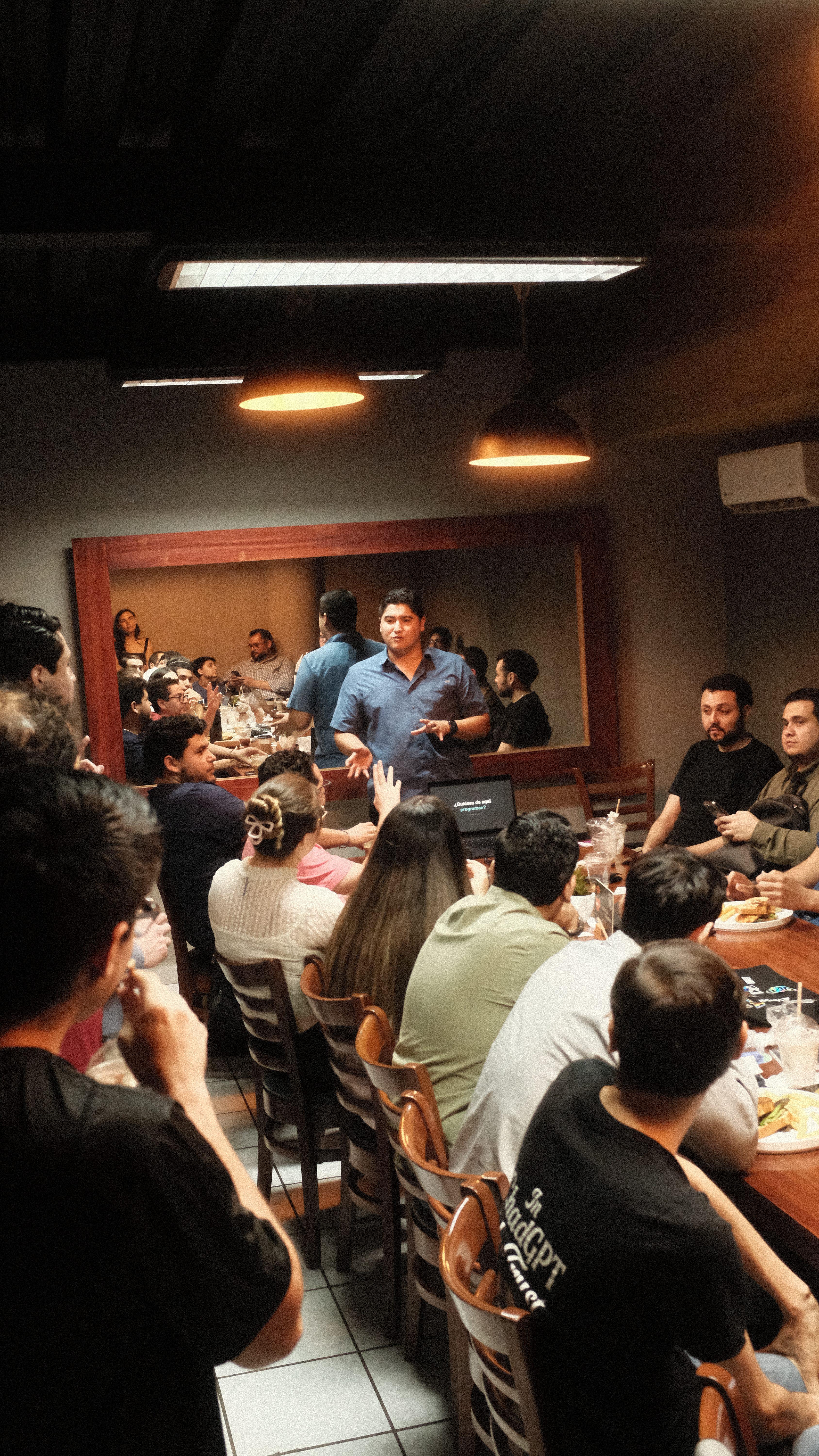 Full table of attendees listening to a talk at Cafe Cursor Culiacán